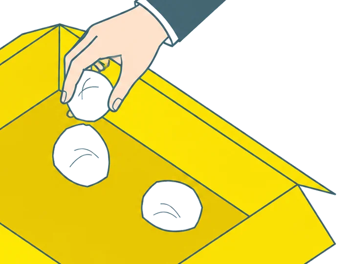 丸めた紙を箱の底に入れている